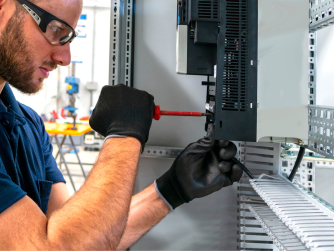 An electrician servicing a business electrical panel